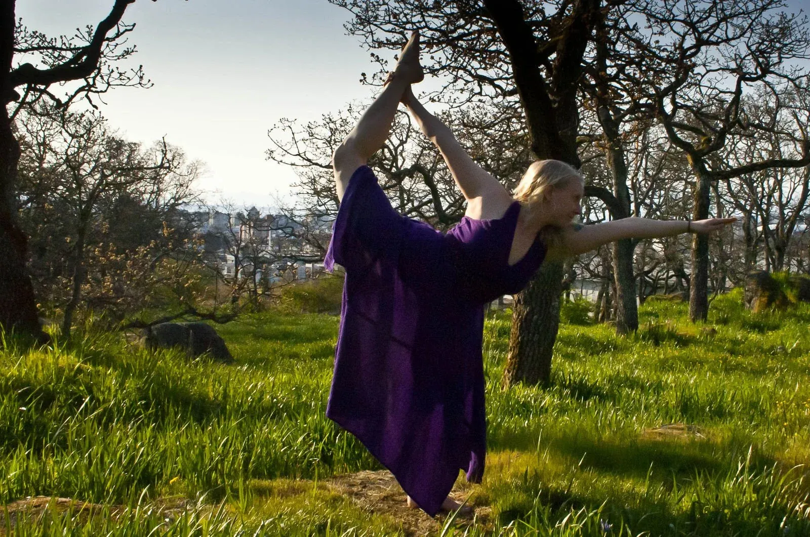 Juliana practising yoga outdoors among trees